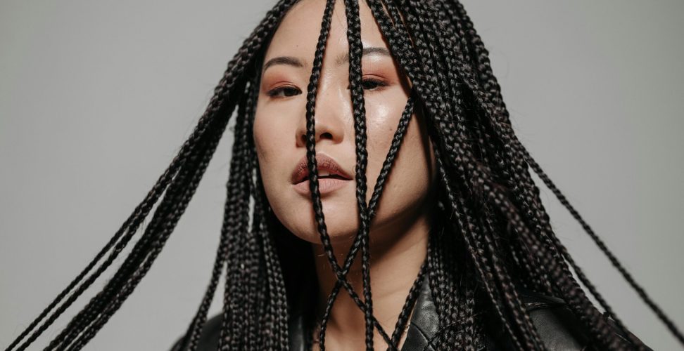 Captivating portrait of a woman with intricate braided hairstyle in a stylish pose.