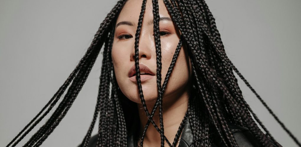 Captivating portrait of a woman with intricate braided hairstyle in a stylish pose.